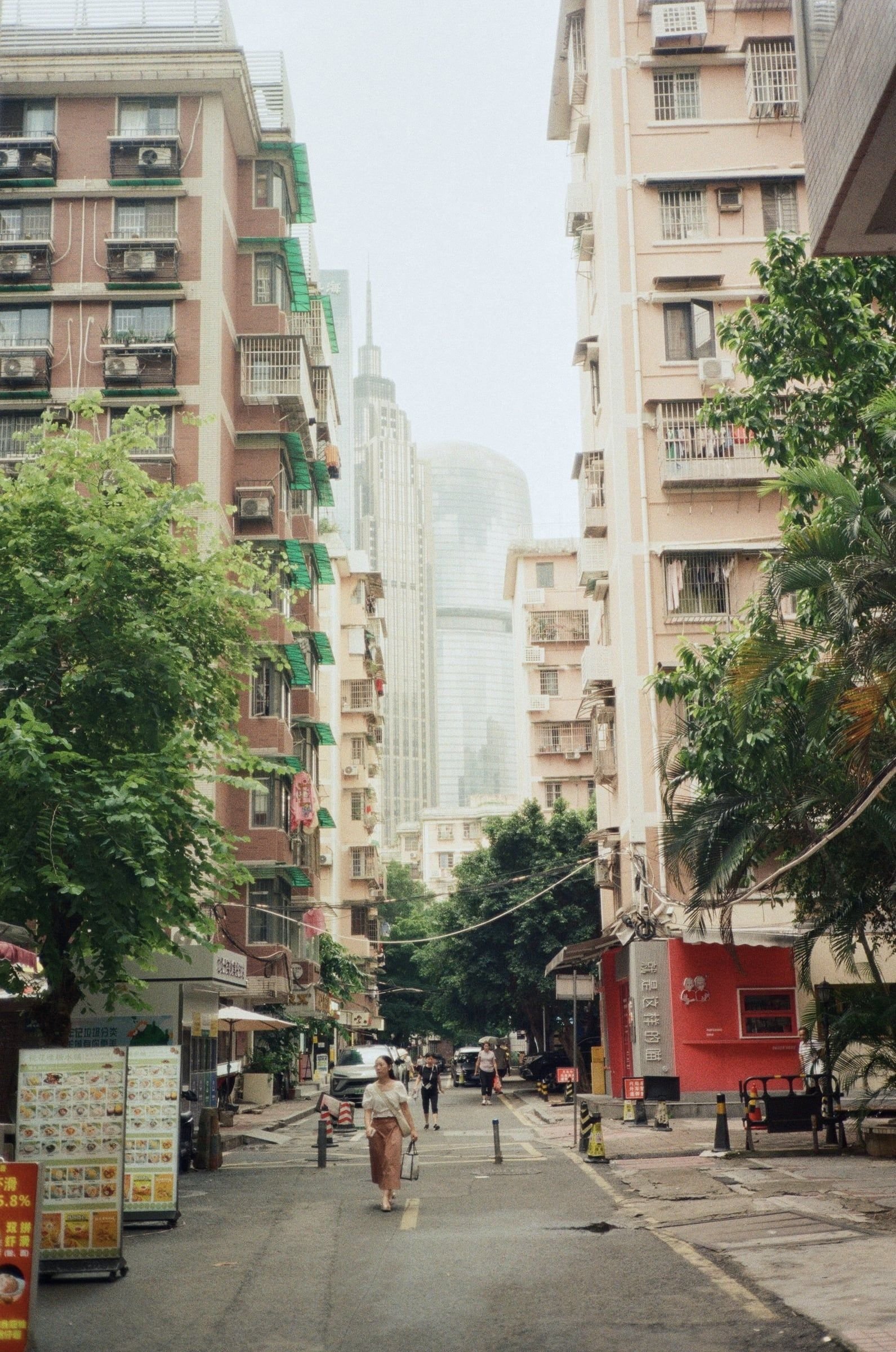 Calle residencial de Guangzhou con edificios de viviendas y rascacielos al fondo