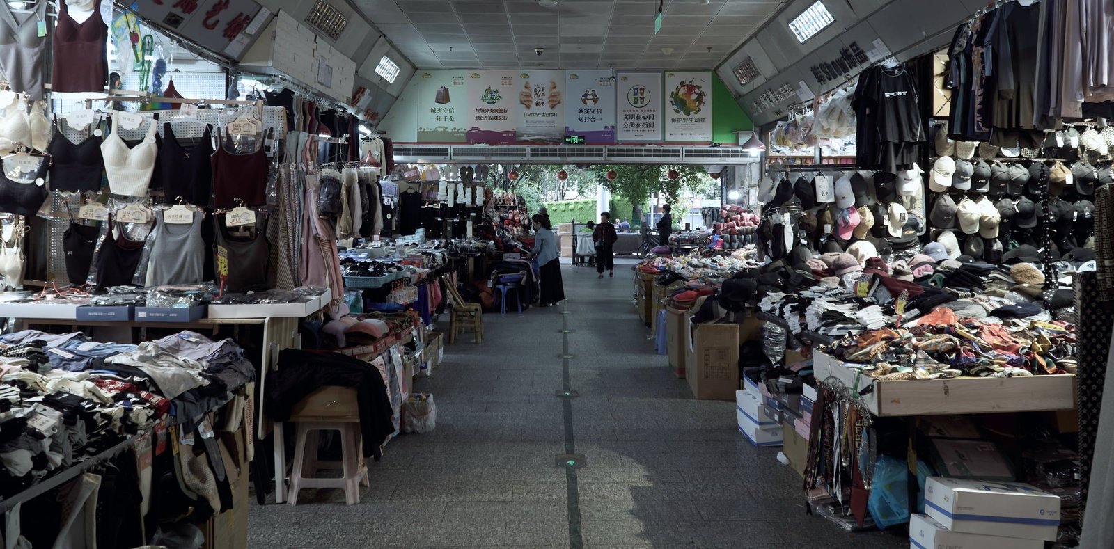 Pasillo de un mercado mayorista chino con puestos de ropa y accesorios